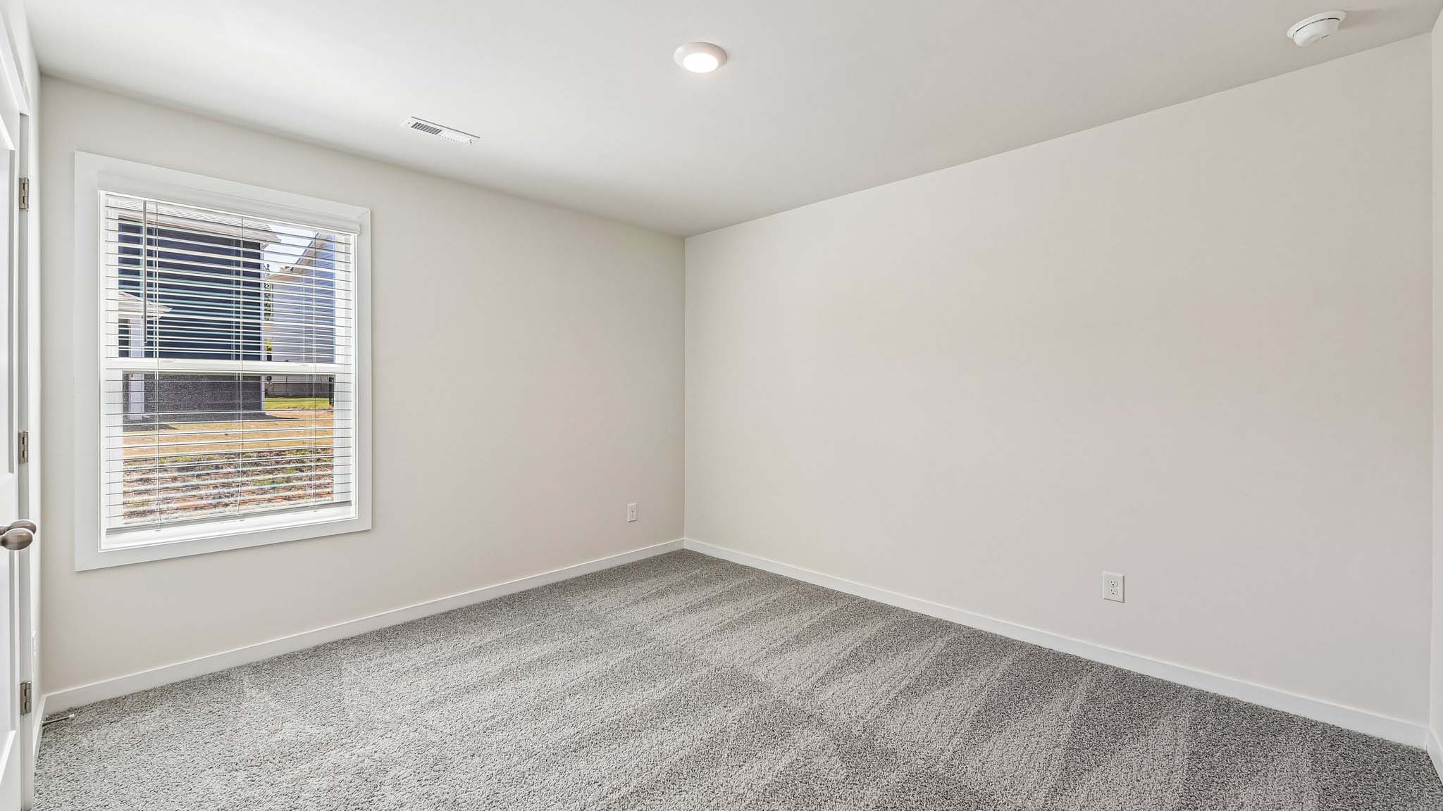 Carpeted bedroom with windows