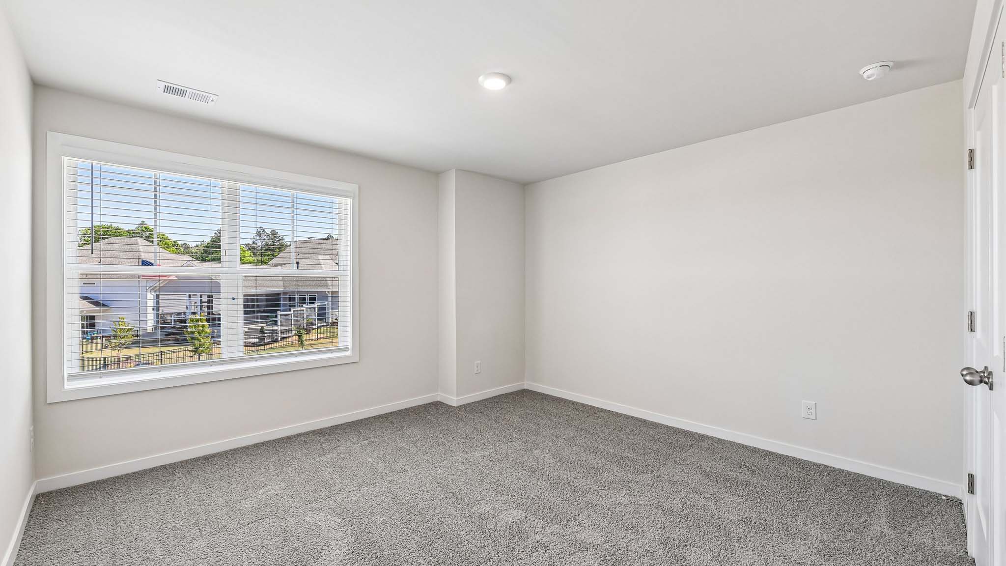 Carpeted bedroom with windows