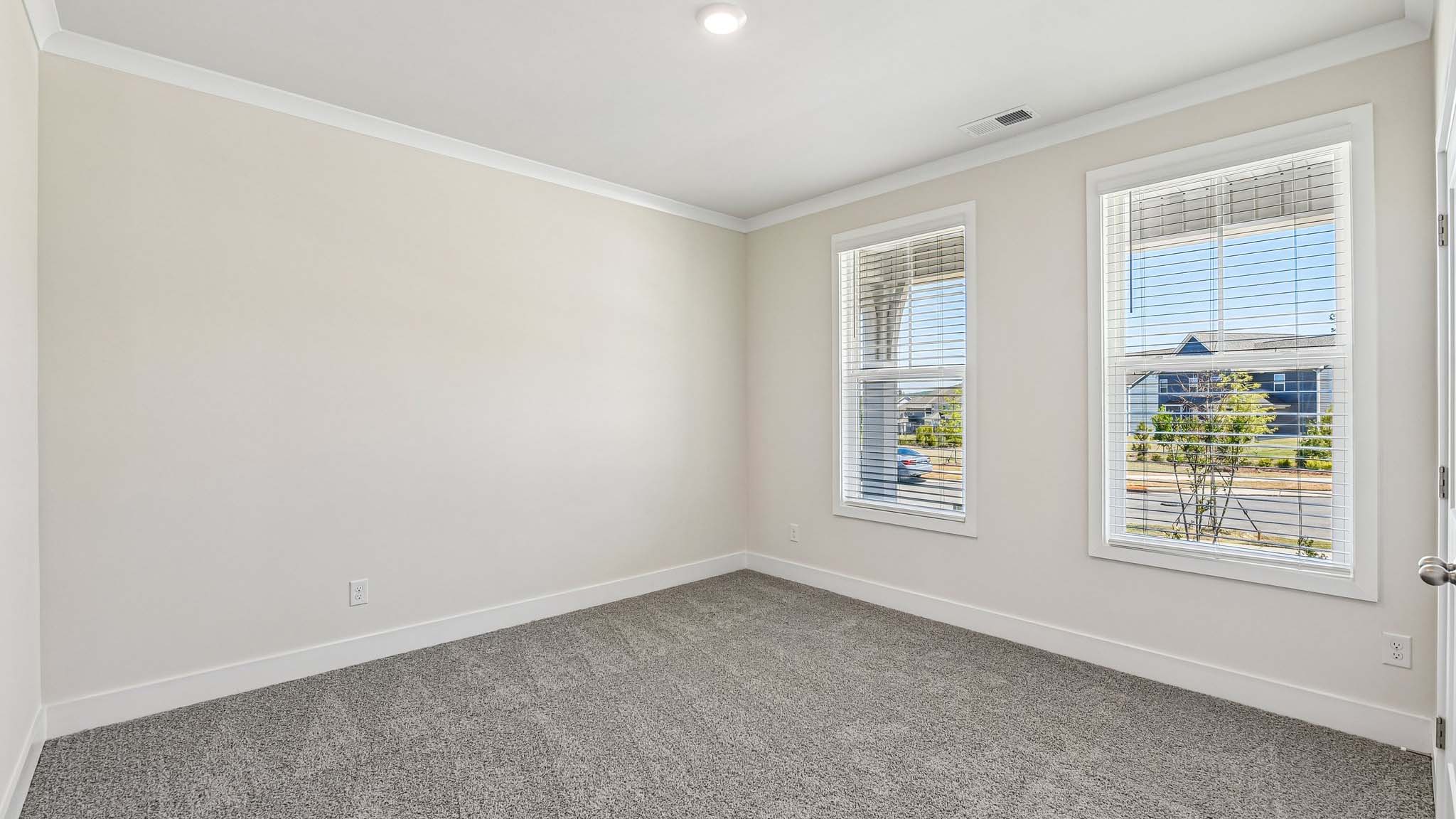 Carpeted bedroom with windows