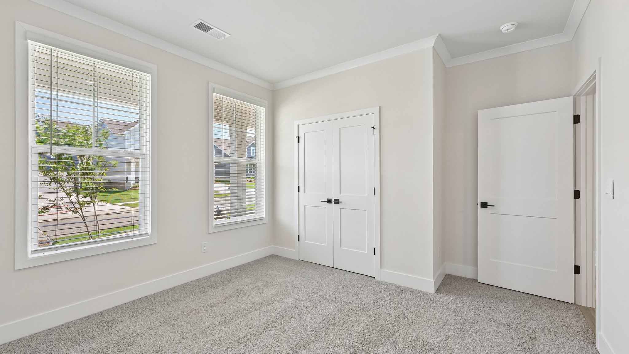 Carpeted bedroom with windows