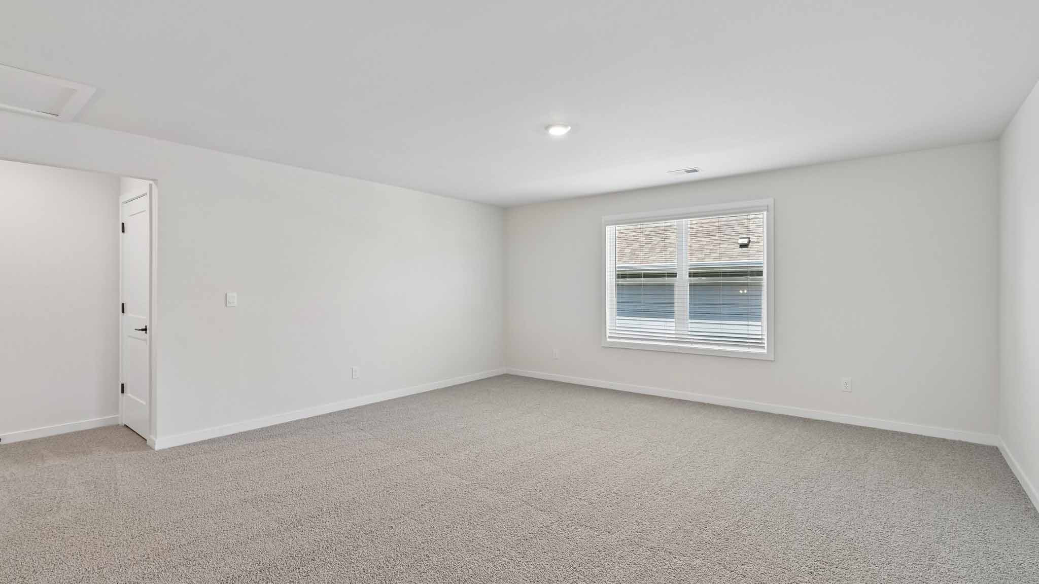 Upstairs carpeted loft with windows