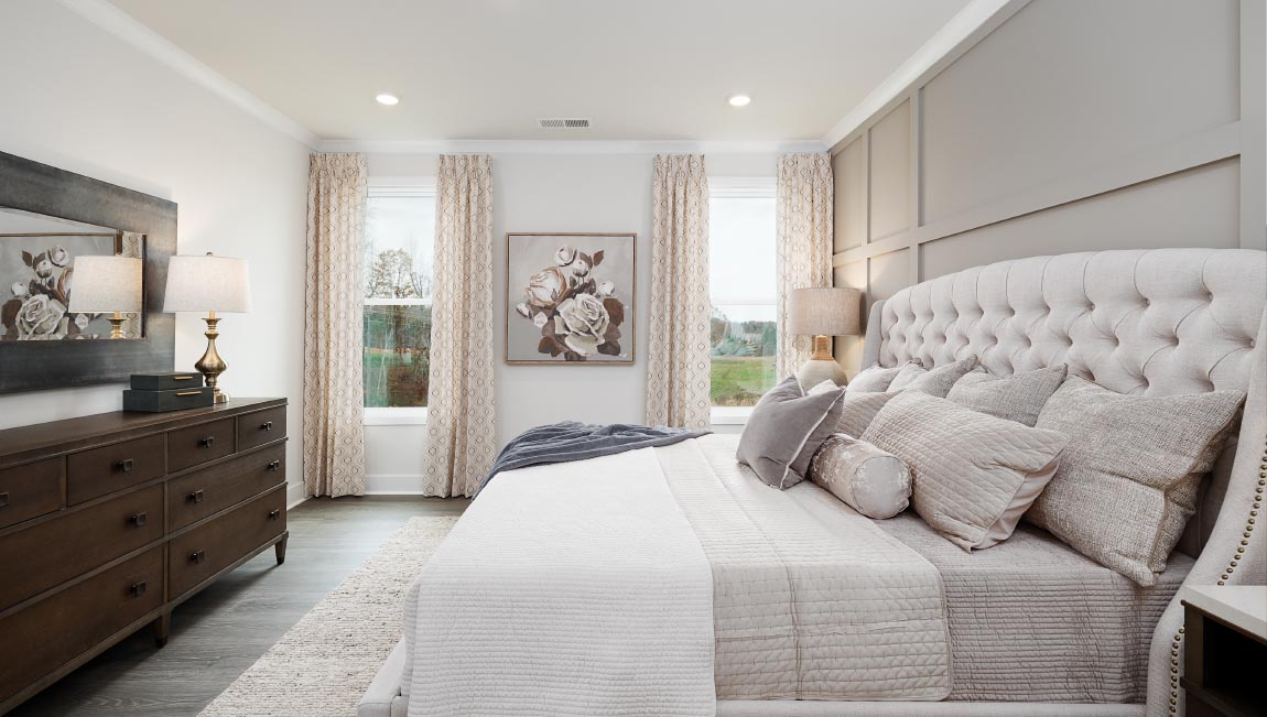 Primary bedroom with carpet and two small windows