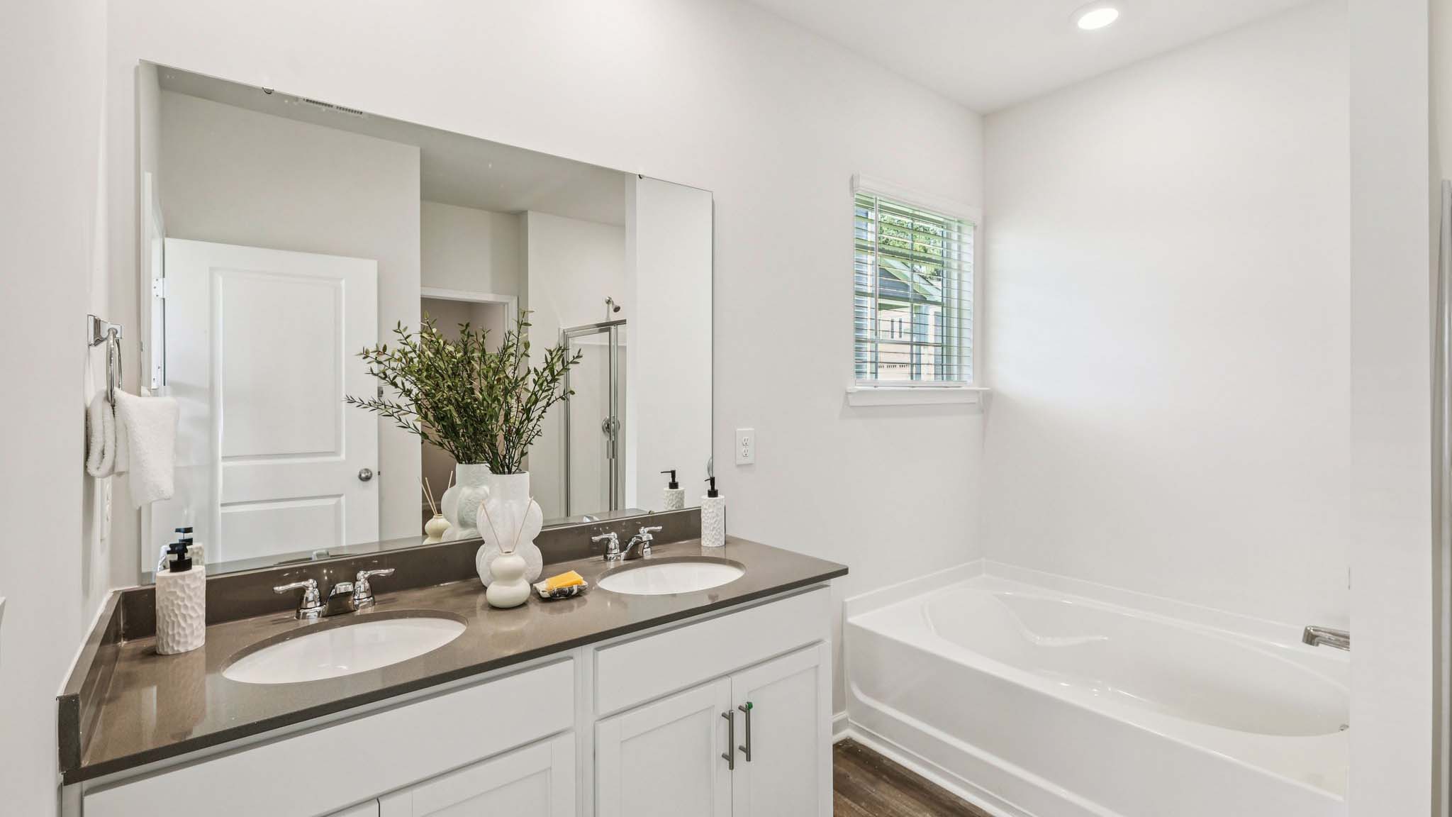 Primary bathroom with standing glass shower and double sinks