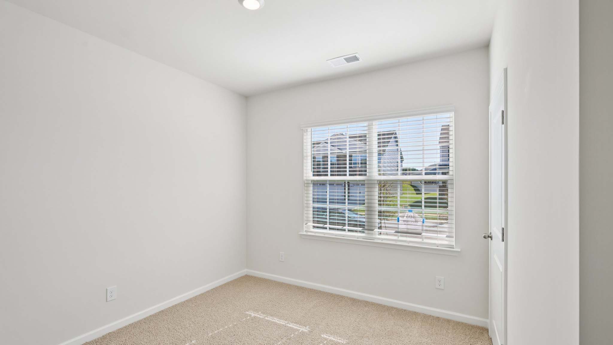 Carpeted bedroom with large window