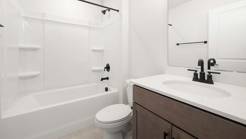 Bathroom with cabinets and white counters, and bathtub