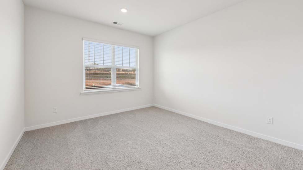 Carpeted bedroom with windows