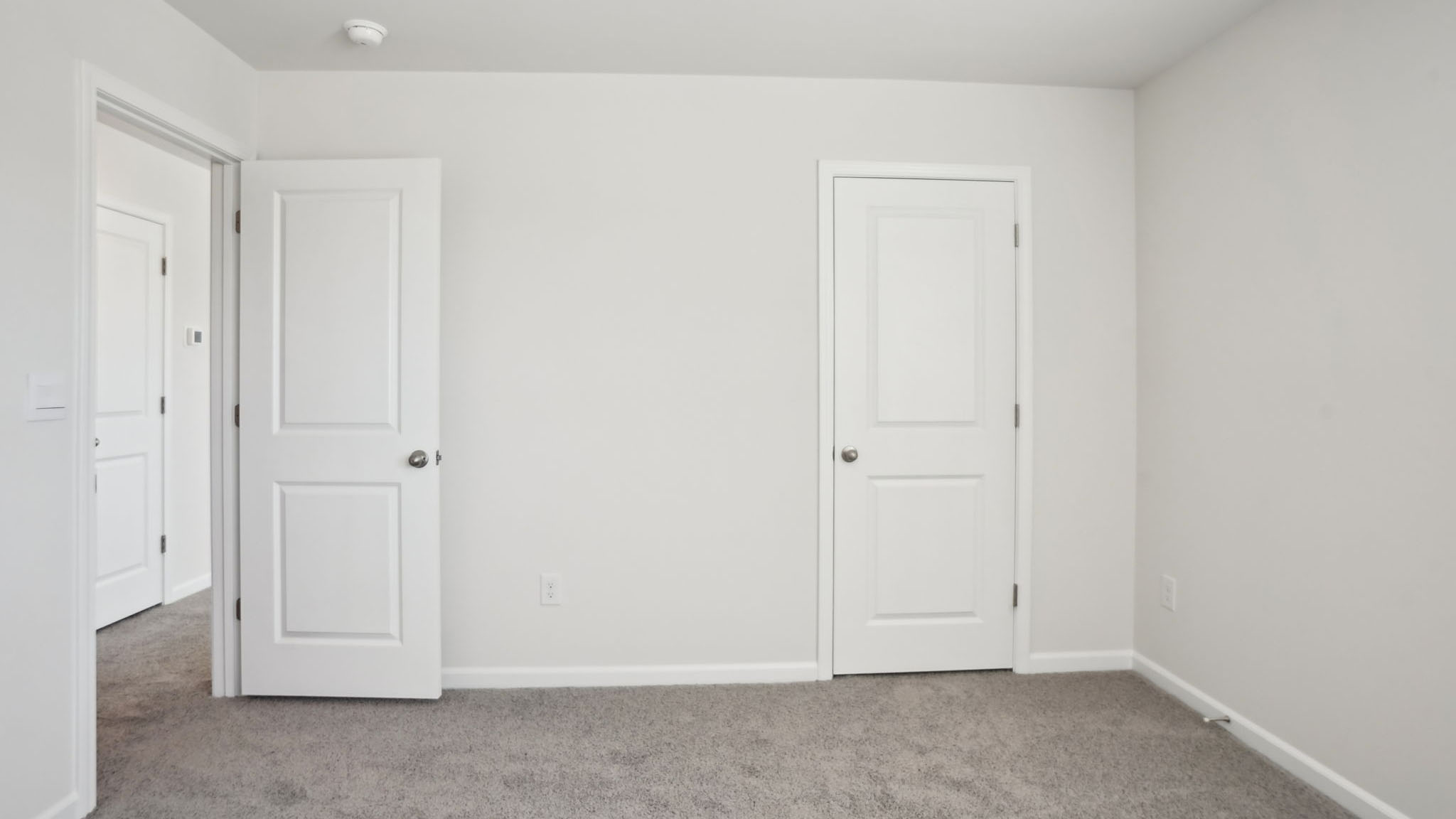 Carpeted bedroom with two large windows