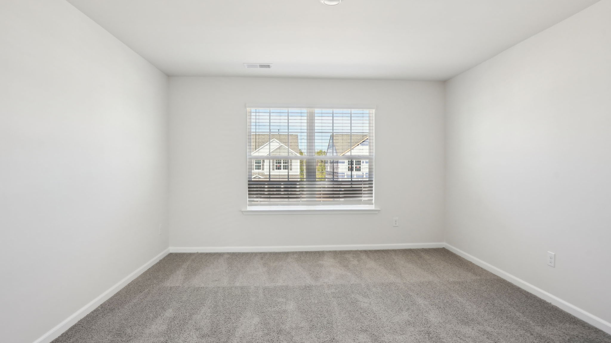 Carpeted bedroom with two large windows