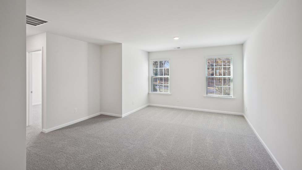 Carpeted loft with windows