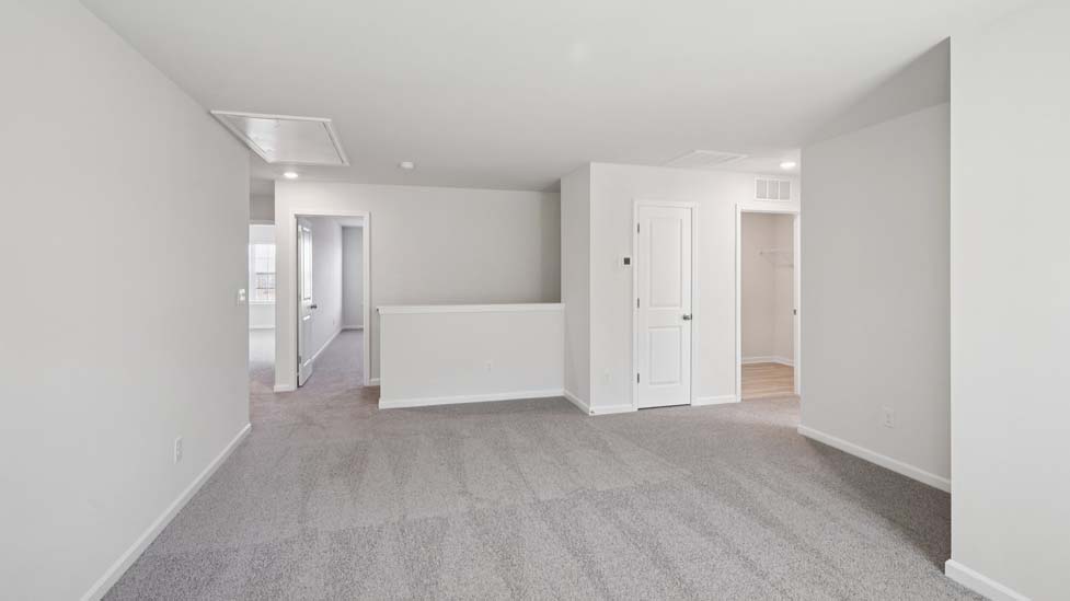 Carpeted loft with windows