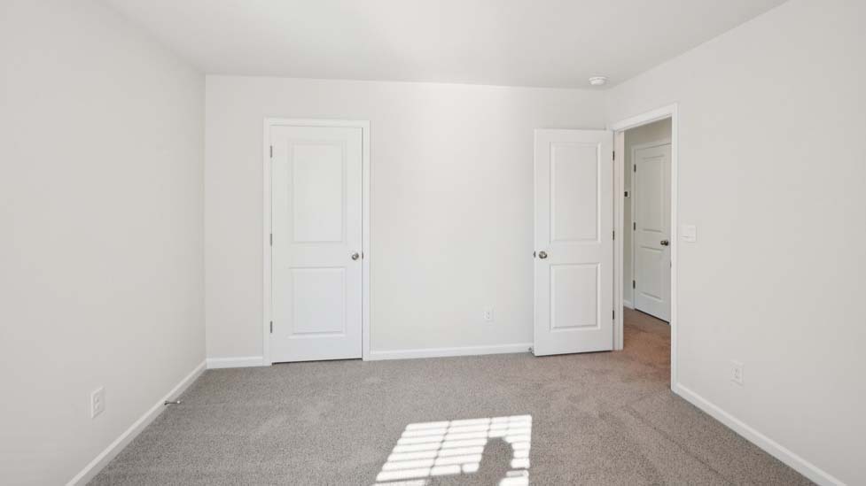 Carpeted bedroom with two large windows