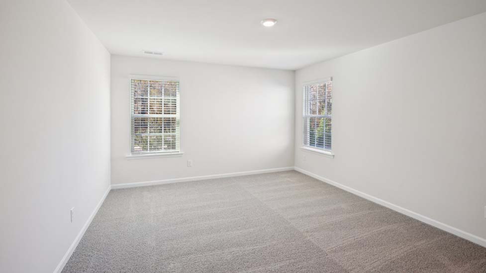 Carpeted bedroom with two large windows