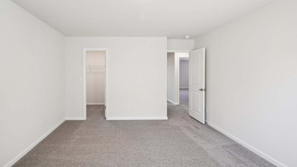 Carpeted bedroom with two large windows