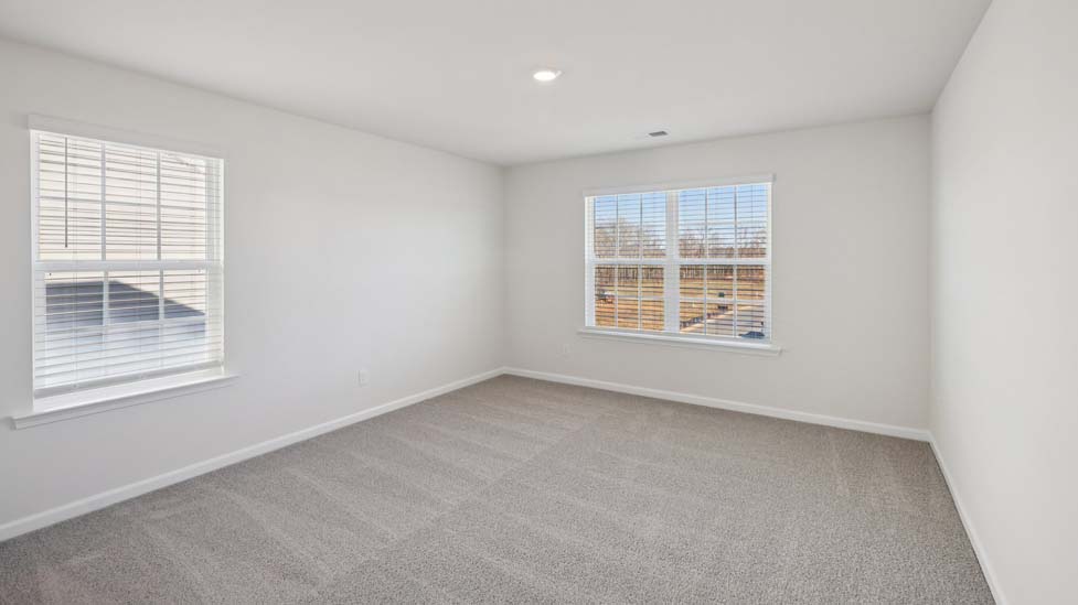 Carpeted bedroom with two large windows