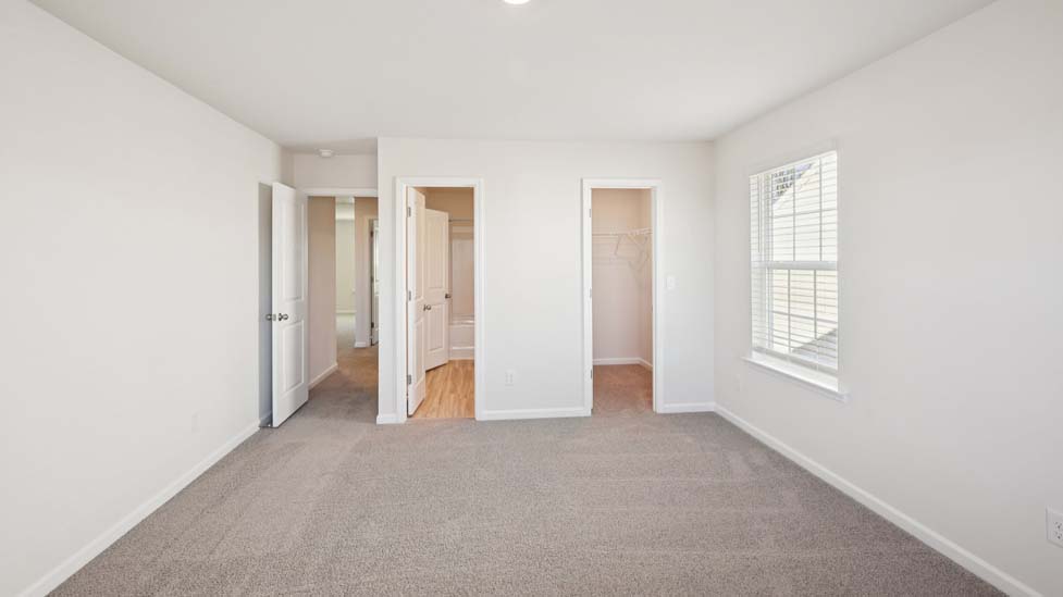 Carpeted bedroom with two large windows