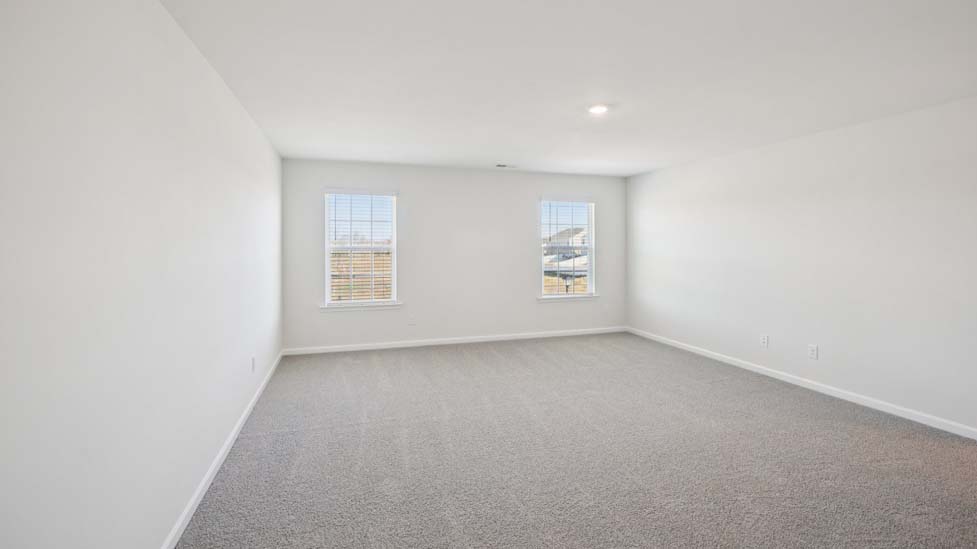 Primary suite, carpeted with two large windows