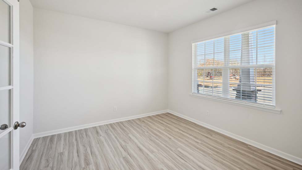 Open family room with fireplace, windows, and view of dining and kitchen