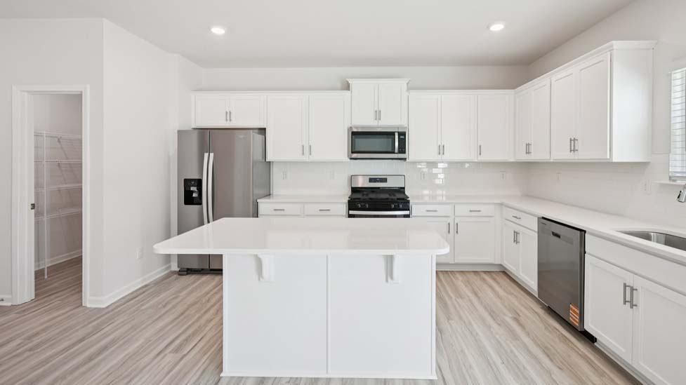 Kitchen and island with white cabinets and counters