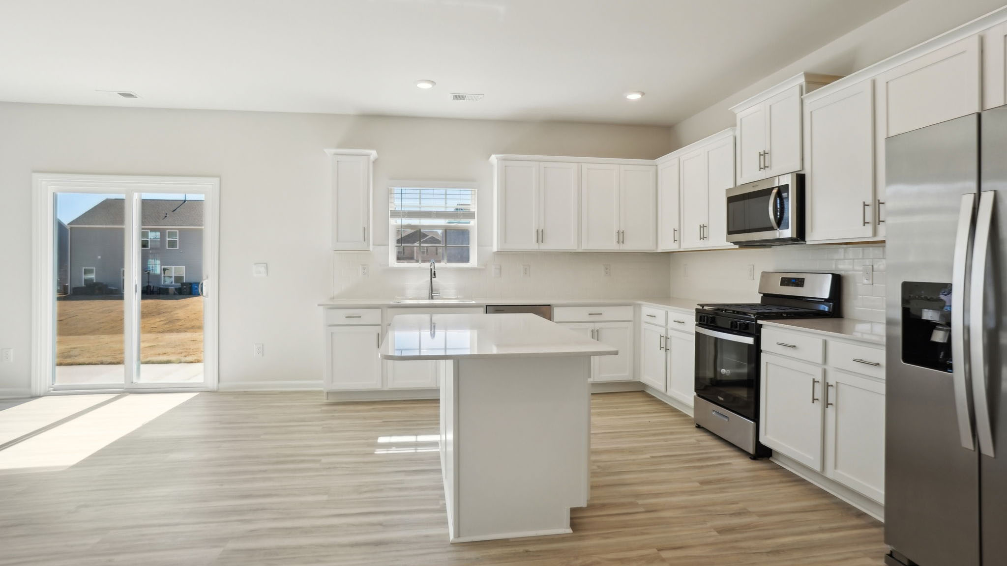 Kitchen and island with white cabinets and counters