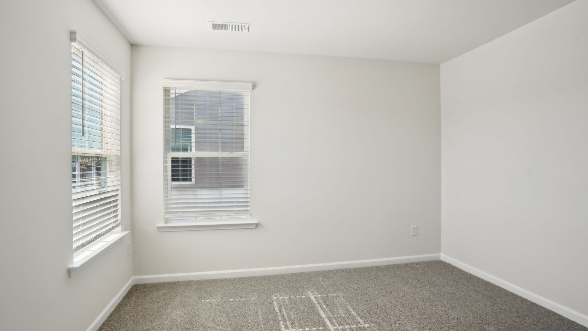 Primary suite, carpeted with two large windows