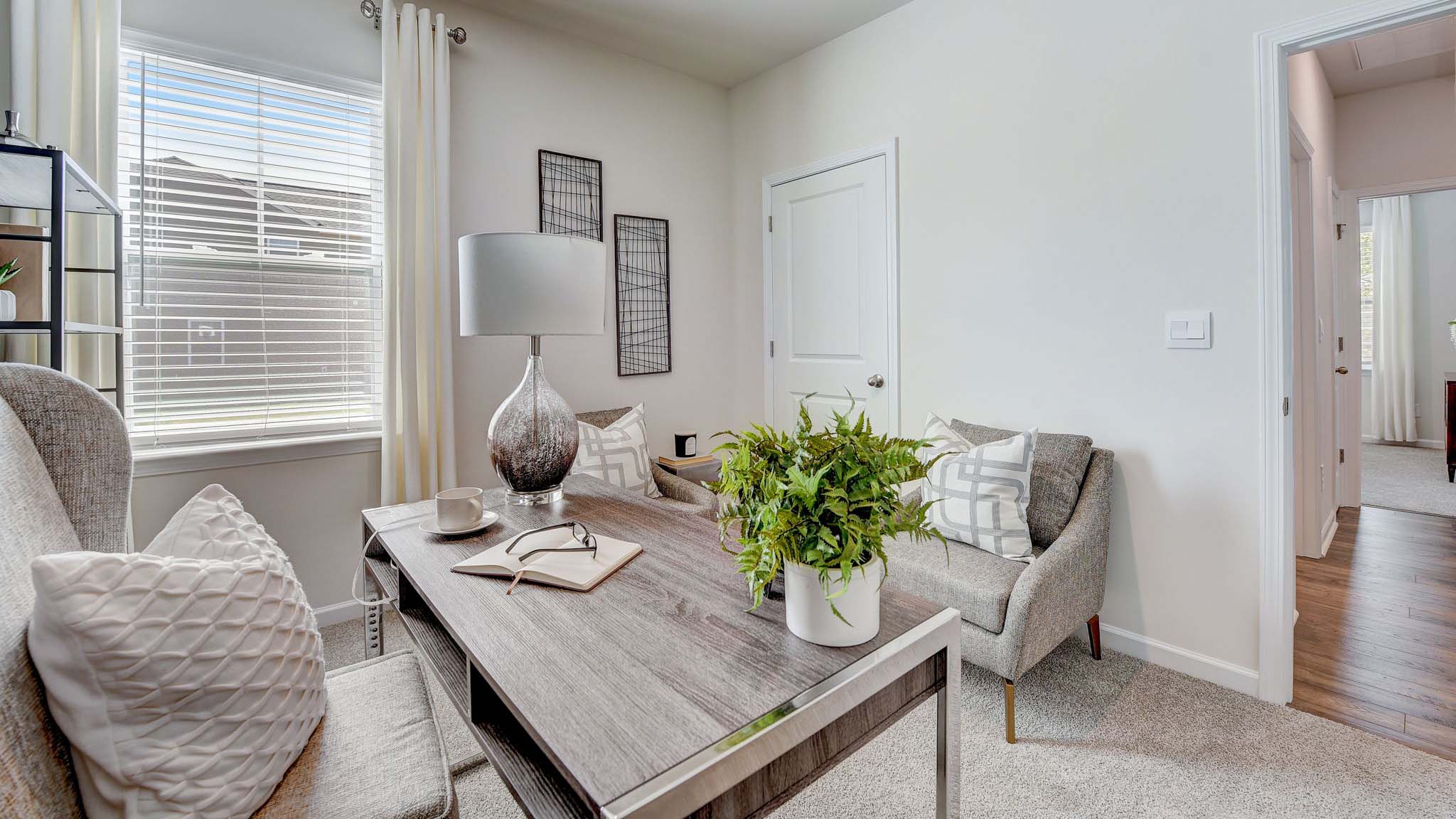 Carpeted bedroom being used as an office with small window