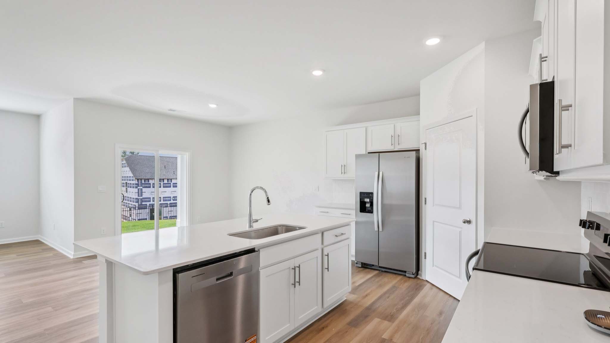 Kitchen and island with white cabinets and subway tiles and stainless steel subway tiles