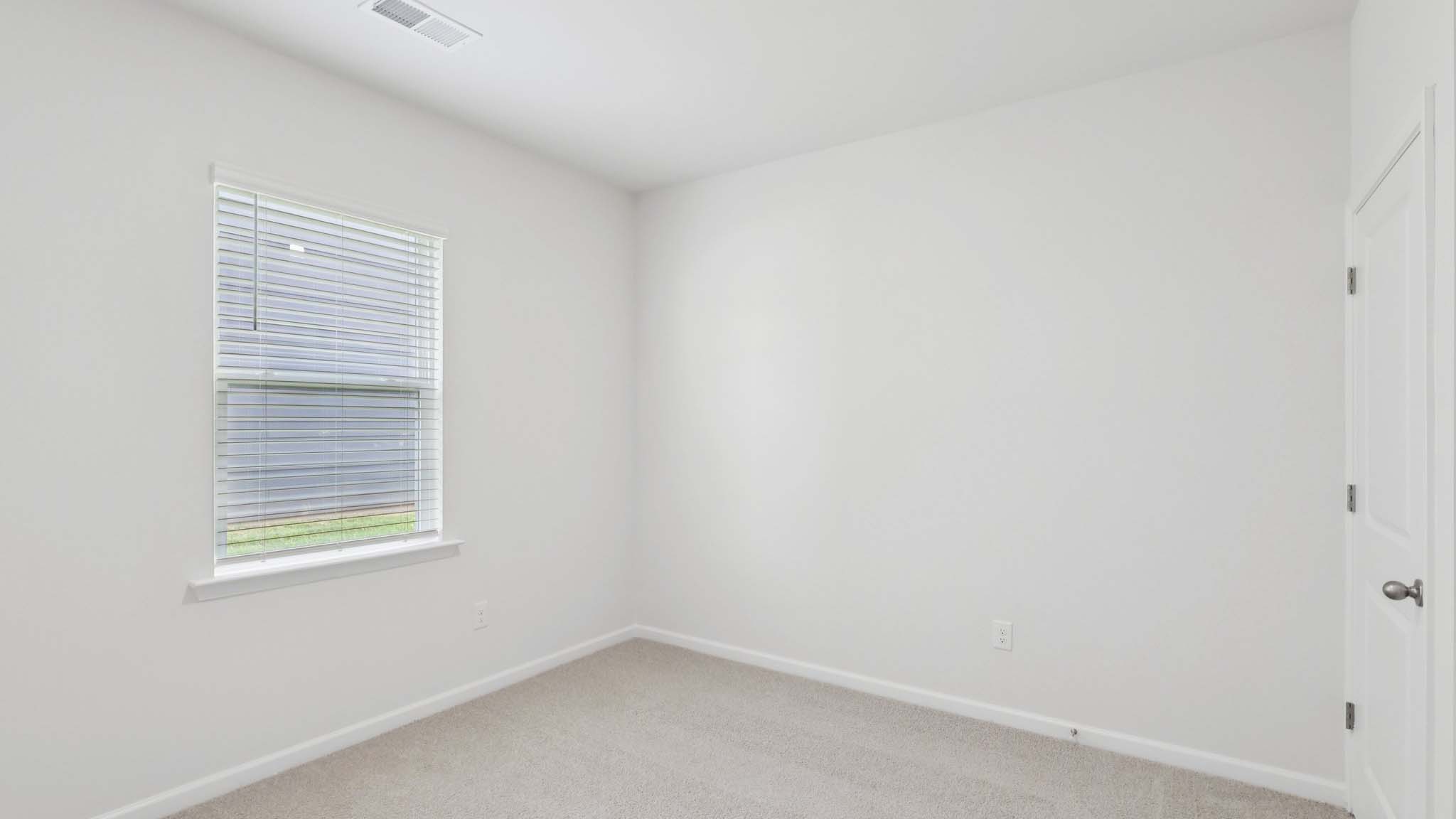 Carpeted bedroom with large window