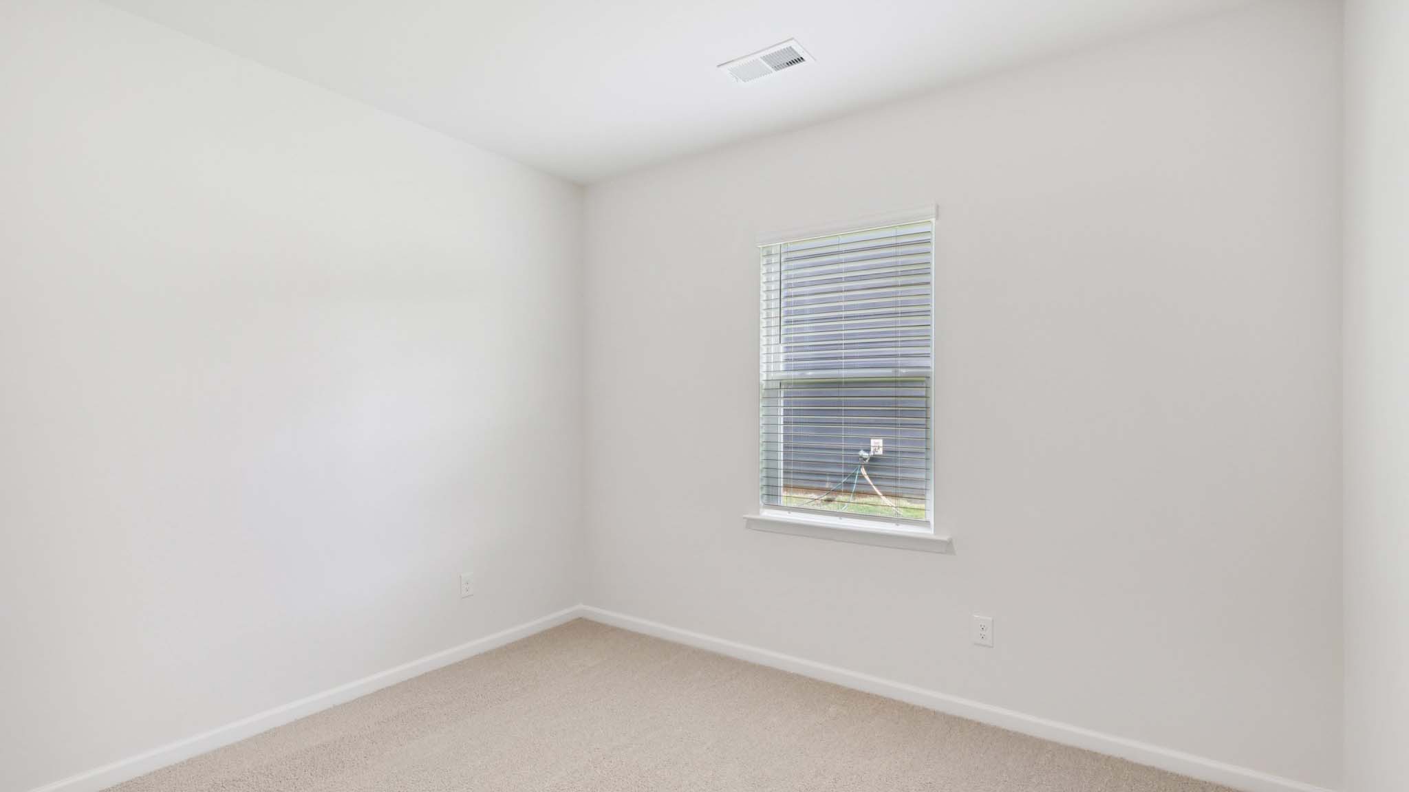 Carpeted bedroom with large window