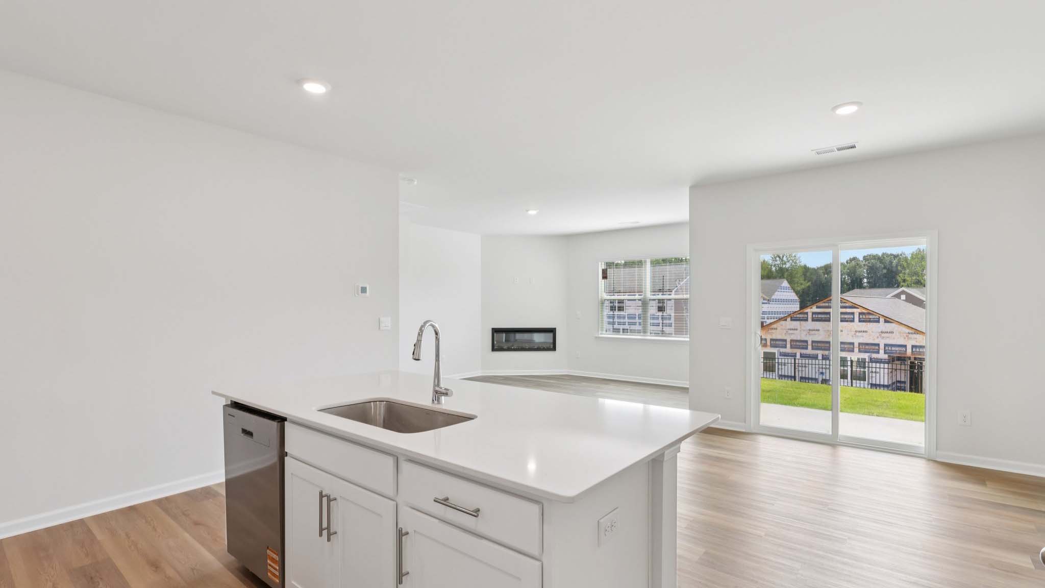 Kitchen and island with white cabinets and subway tiles and stainless steel subway tiles