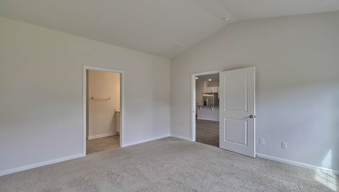 Primary carpeted bedroom with windows