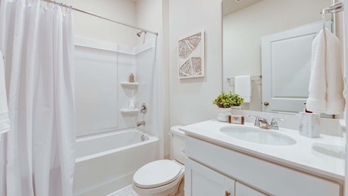 Bathroom with bathtub, and white cabinets and counter