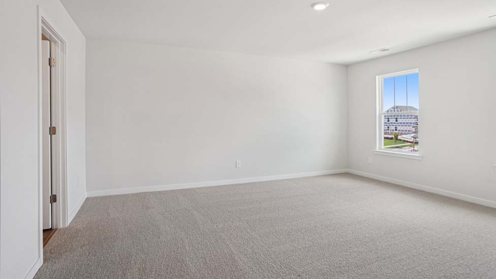Primary bedroom with wood floors, two large windows