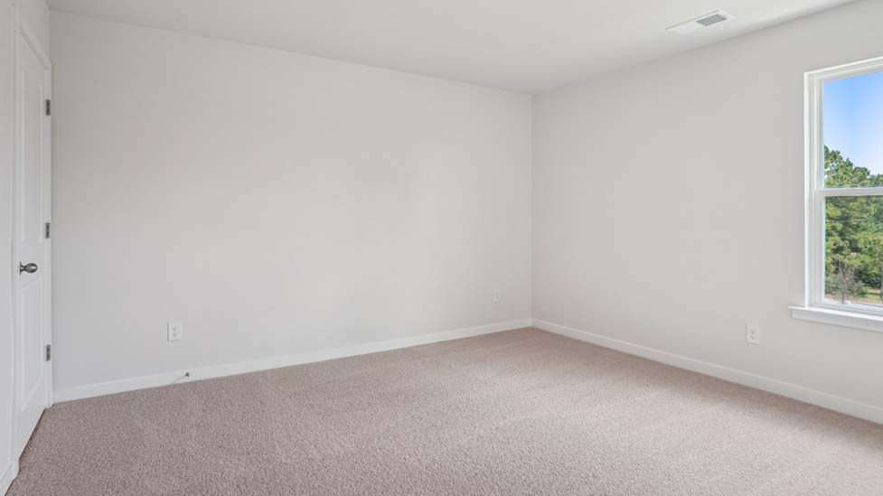 Carpeted bedroom with large windows