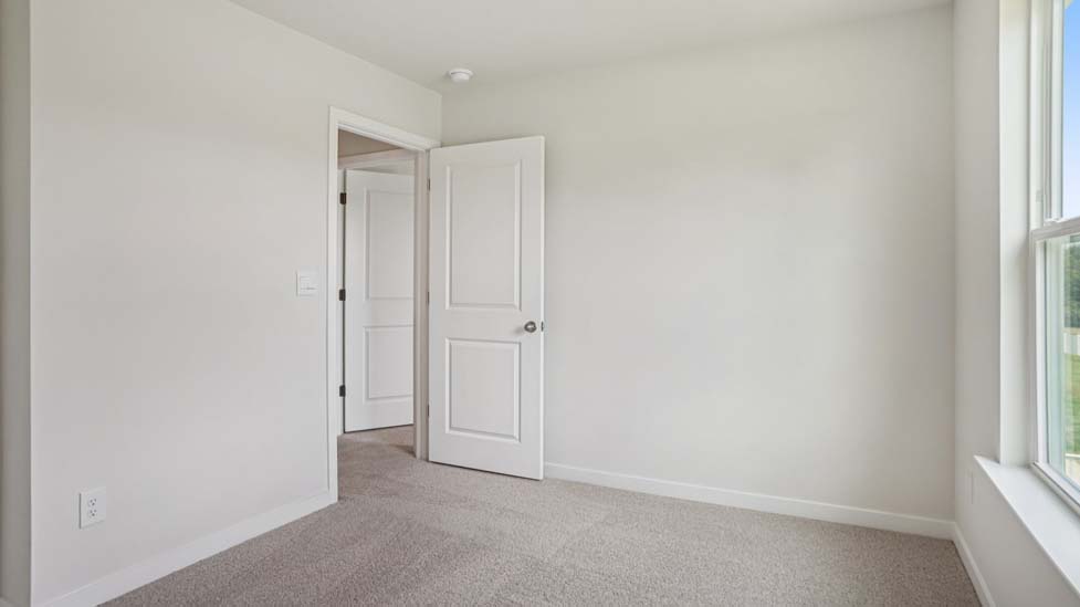 Carpeted bedroom with large windows