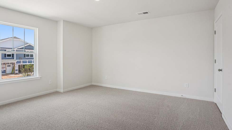Carpeted bedroom with large windows