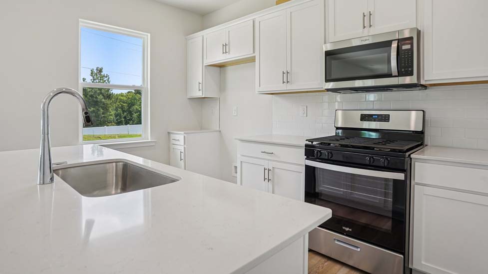 Kitchen with island, white cabinets and wood floors