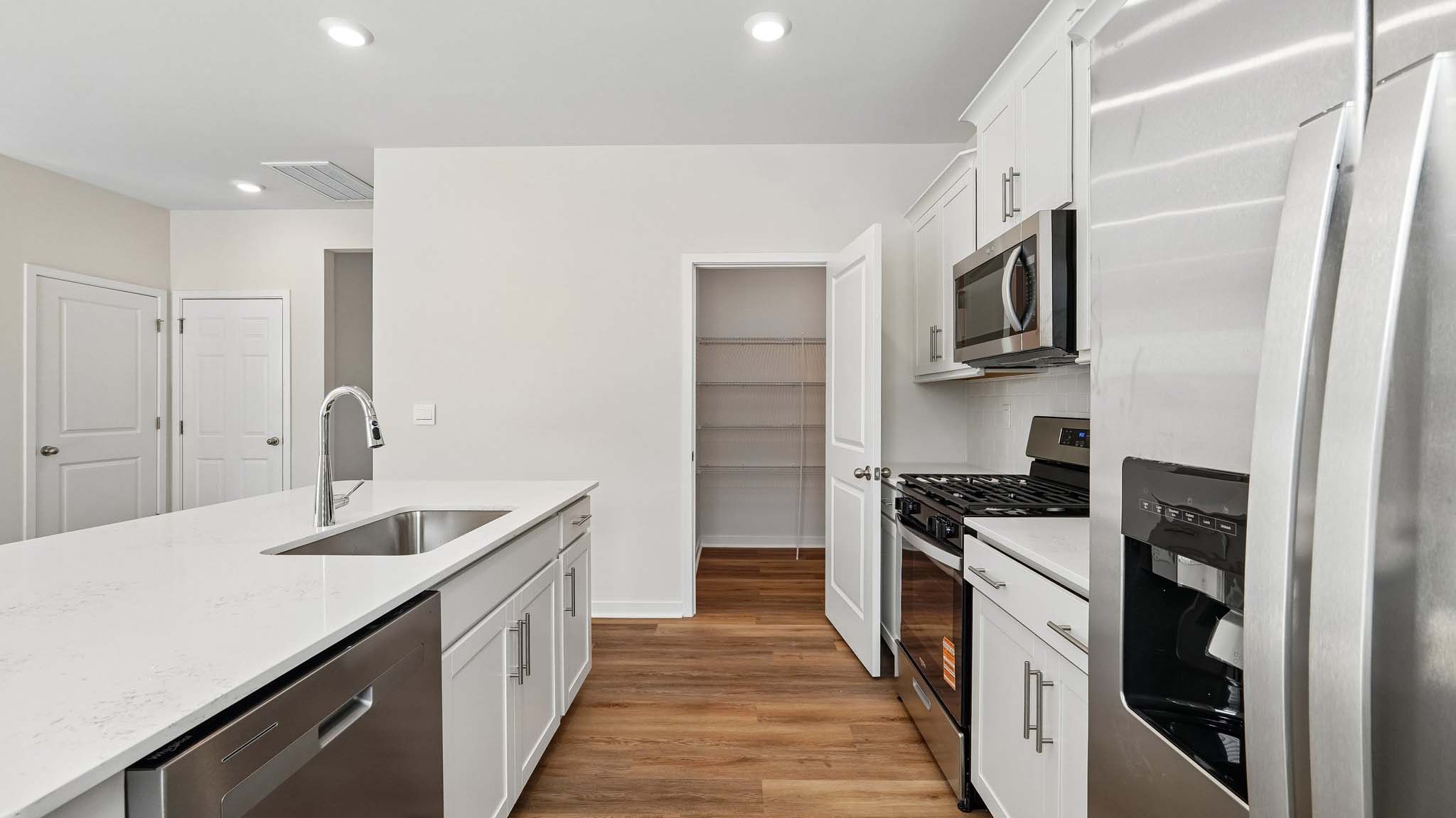 Kitchen with island, white cabinets and wood floors