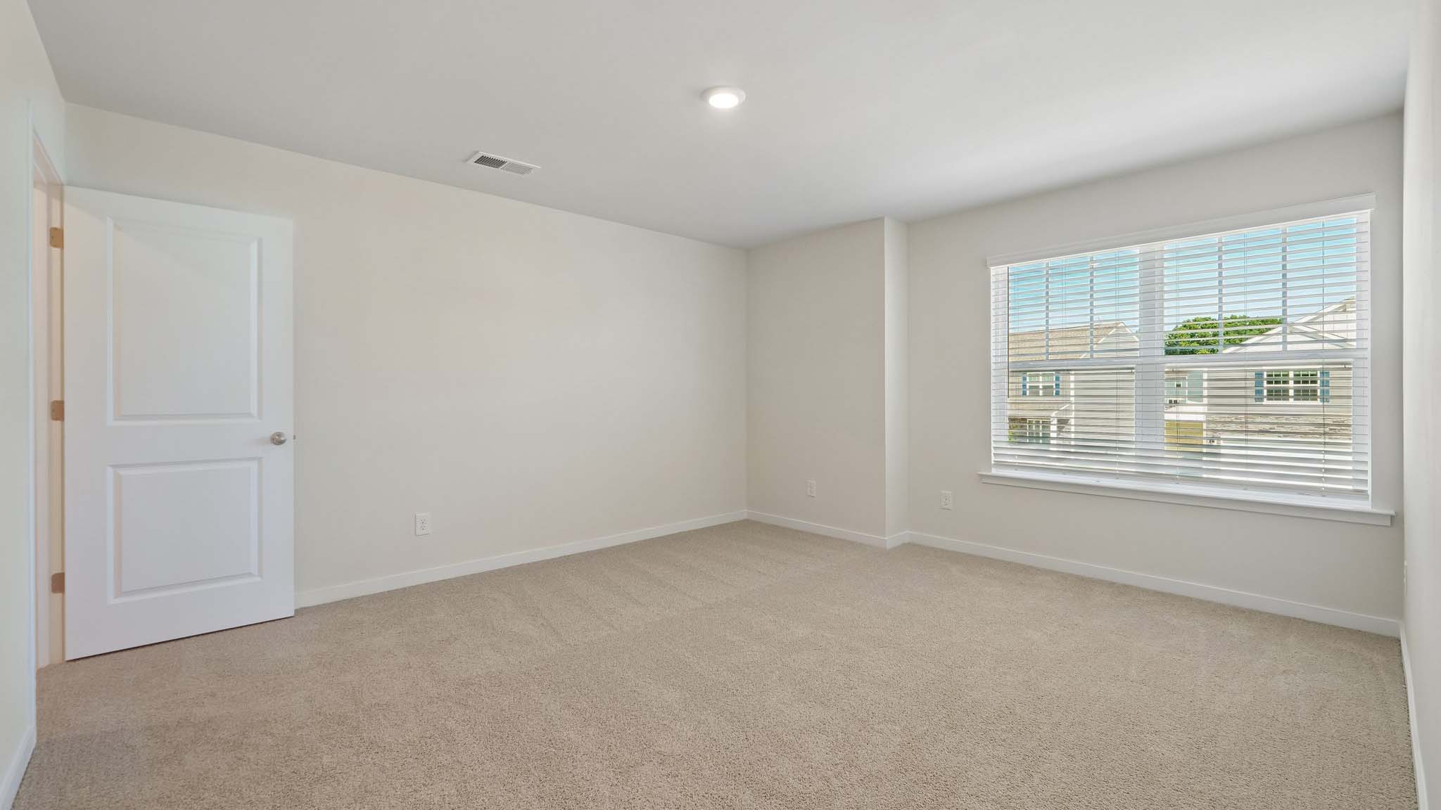 Carpeted bedroom with large windows