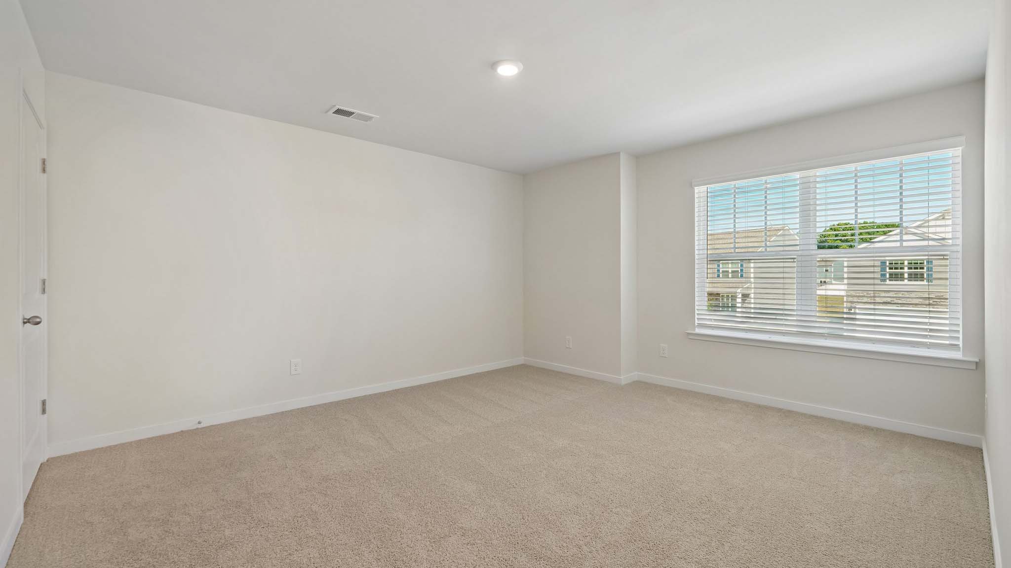 Carpeted bedroom with large windows