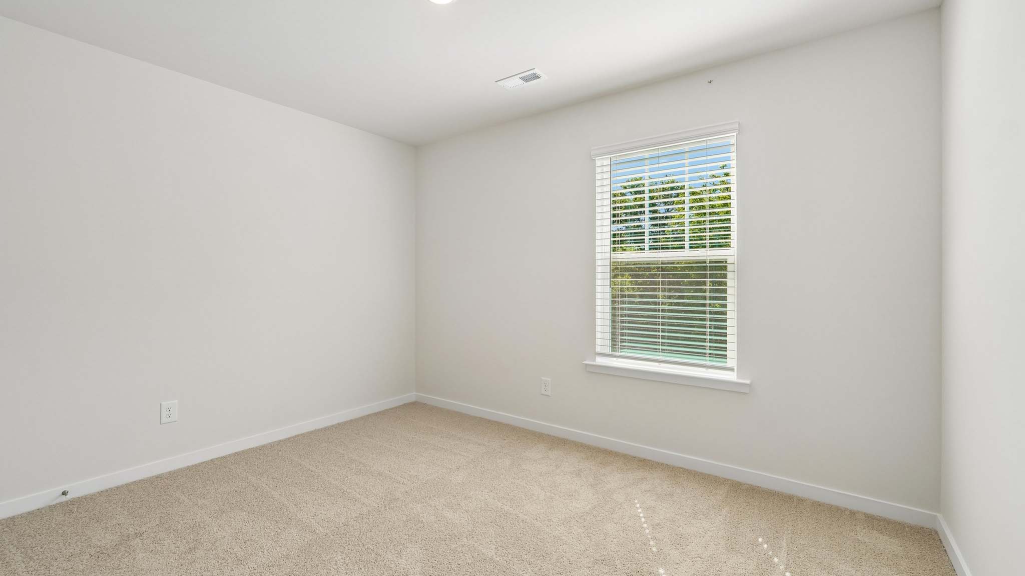 Carpeted bedroom with large windows