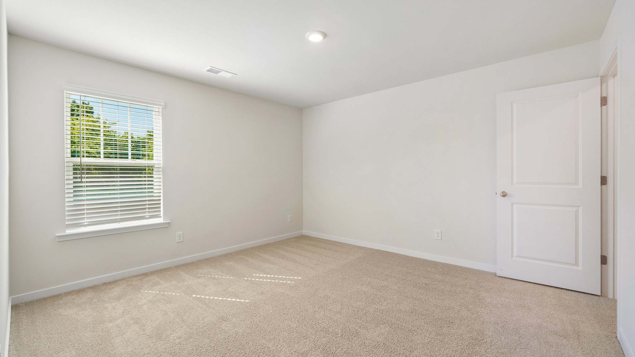 Carpeted bedroom with large windows