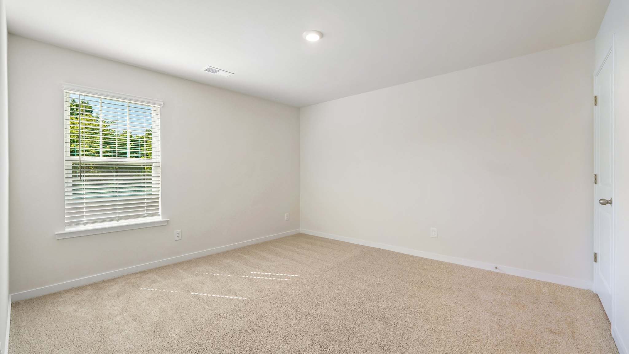 Carpeted bedroom with large windows