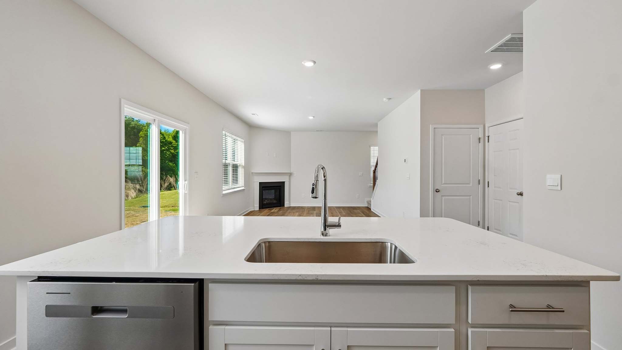 Kitchen with island, white cabinets and wood floors
