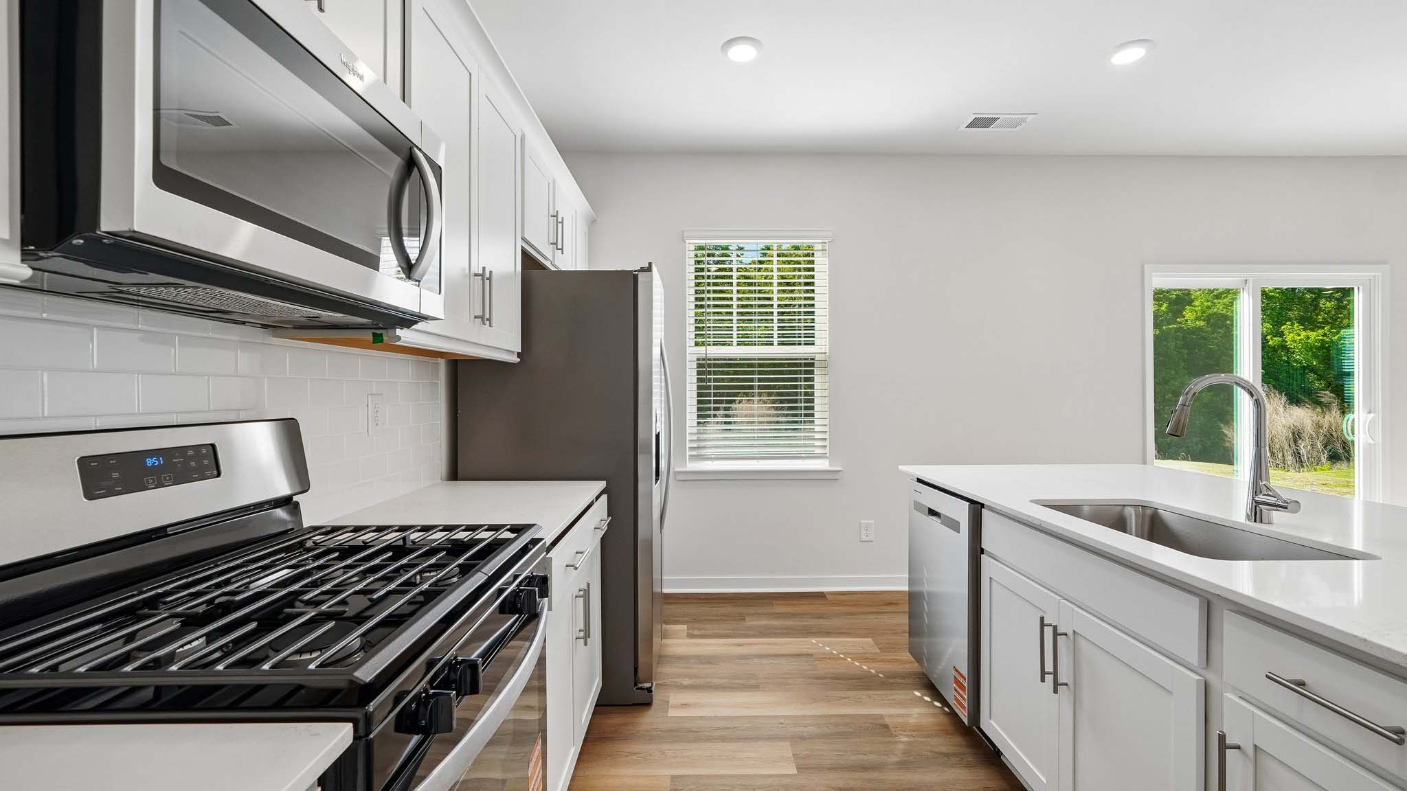 Kitchen with island, white cabinets and wood floors