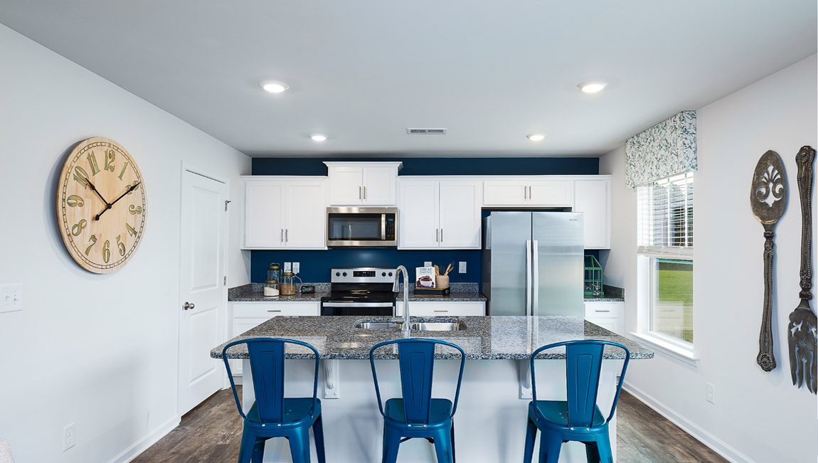 Kitchen with island, white cabinets and wood floors