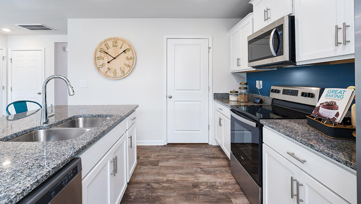 Kitchen with island, white cabinets and wood floors