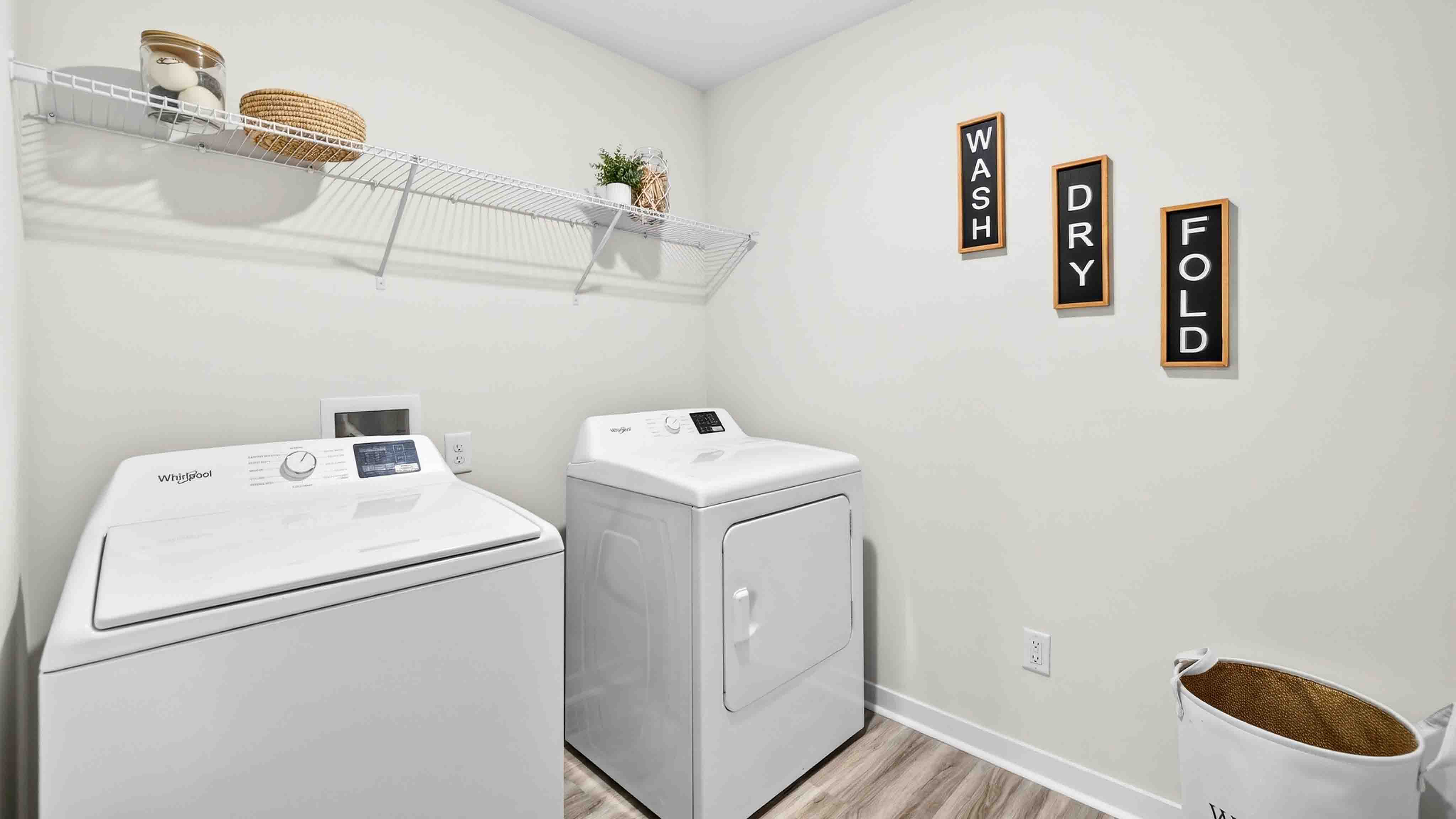 Laundry room with storage hanging racks above machines