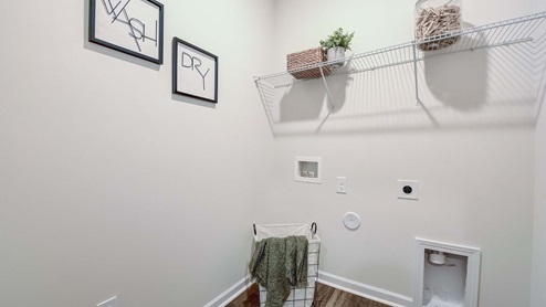 Laundry room with storage racks above machine space