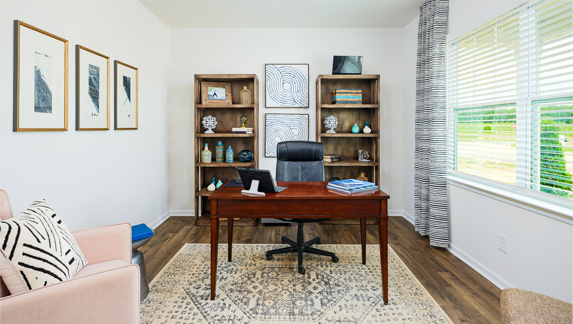 Flex space with large window, being used as office, with french doors at entrance