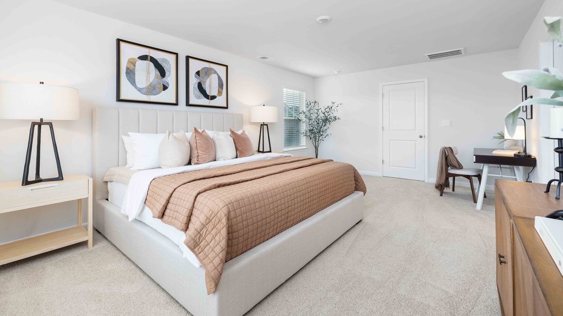 Primary bedroom with large window, carpet and door to bathroom